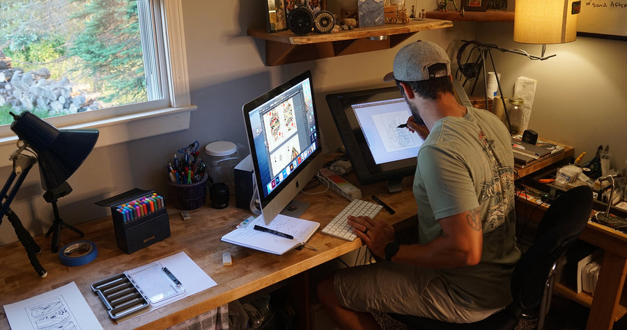 A man draws on a computer screen at a studio workspace.